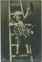 Kind auf der Leiter mit Blumen